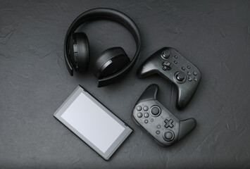 Black devices: gamepads, headset and tablet pc. Gaming concept on black background © rvlsoft
