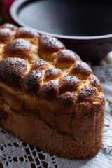 Braided bread sprinkled with poppy seeds on the textile napkin