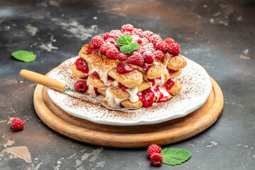 berry tiramisu with biscuit with coffee cream and fresh berries. Tiramisu with raspberry on a dark background © Надія Коваль