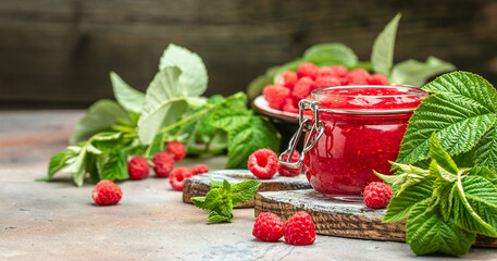 Homemade raspberry jam in jar with raspberries and mint. Long banner format. place for text
