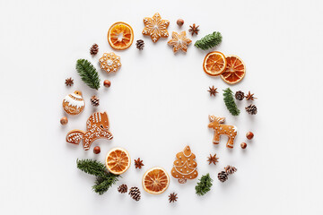 Christmas round frame. The frame is made of Christmas gingerbread, nuts, cones, dried orange slices and anise stars on a white background.
