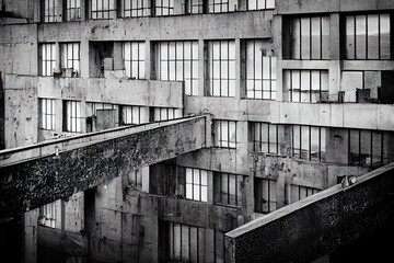 Photorealistic illustration of an abandoned industrial building in black and white, generated by ai, is not based on any real image
