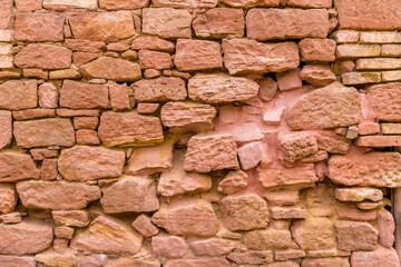 Mauer aus groben rotem Sandstein mit tiefen Fugen