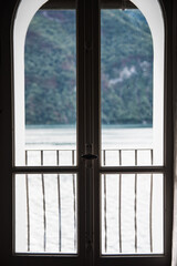 A window with Lake Lugano in the background in Switzerland during the summer. 