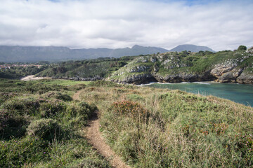 Fototapeta na wymiar Llanes at North of Spain at Asturias region is an amazing place for enjoying the outdoors with amazing wild and green beaches like this panoramic view of Poo beach