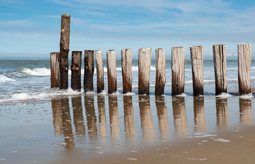 Sand, a wooden pier and reflections at the Cadzand beach