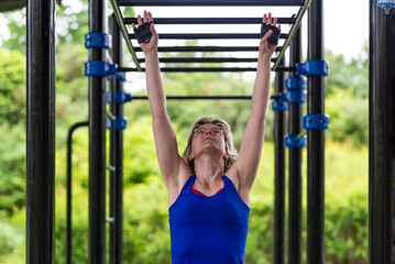 Obraz premium Young woman jumping towards a fitness rack