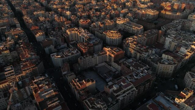 Aerial view of Barcelona city skyline and Sagrada Familia Cathedral at Sunset. Eixample residential famous urban grid. Cityscape with typical urban octagon blocks. Catalonia, Spain 4k Aerial View