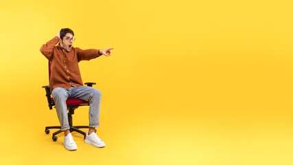 Fototapeta na wymiar Shocked Man Pointing Finger Aside At Empty Space, Yellow Background