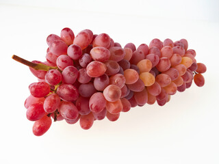 Ripe red grapes. Pink bunch with leaves isolated on white. With trajectory cropping. Full depth of field.