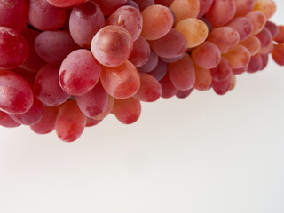 Ripe red grapes. Pink bunch with leaves isolated on white. With trajectory cropping. Full depth of field.