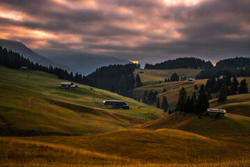 Cloudy sunrise in mountain meadow Seiser Alm in Dolomites