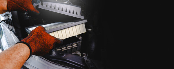 Car air filter being inserted into air filter box in the automobile engine compartment by auto...