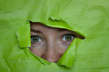 green eyes on a green background, the girl looks out, emotions, parts of the face, surprise, green...