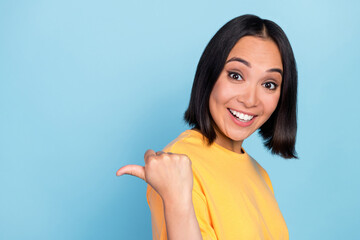 Photo of impressed ecstatic lovely girl with bob hairdo wear yellow t-shirt indicating empty space isolated on blue color background