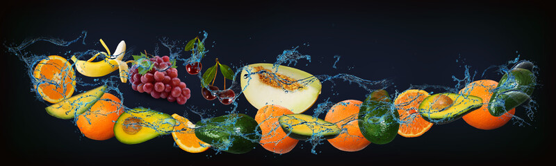 Fototapeta na wymiar Panorama with fresh fruits in the water - pineapple, orange, avocado, melon, grapes, banana, a very tasty dessert for the New Year, Christmas and Halloween