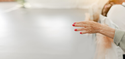 Elderly woman with red manicure, wrinkled hand palm with, clearly visible veins reaching out...
