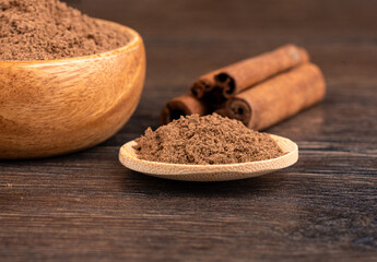 Selective focus on ground cinnamon on a wooden background.