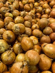 Vertical shot of onions pile in the grocery store