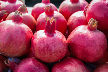 Background from fruits of a ripe pomegranate. Close-up. Pomegranate fruits are eaten raw, pomegranate juice is made from them. Sale of fruits in the market. Healthy food.