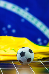 Naklejka premium Soccer Ball and Brazil Flag over Photovoltaic Solar Panel. World Cup and Technology Concept Image for Design.