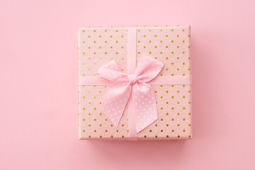 Gift box with ribbon on pink background. Flat lay image.