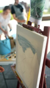 Woman drawing her picture on canvas with oil colors