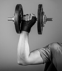 Male arm lifting dumbbell close up. Holding gyms weight for strong biceps