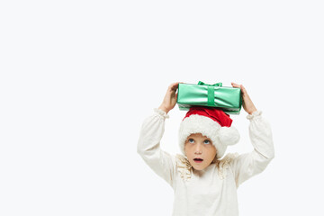 Christmas child. Cute toddler girl  in santa claus caps holding colorful gift boxes on white. Wow fanny face. Preparing for New Year's holidays in Italy