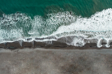 Aerial view of chilean ocean with black snd beach. Top view from drone
