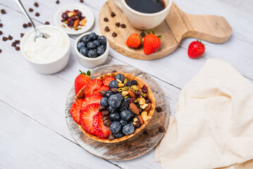 Yogurt and fruit in a waffle bowl. Greek yogurt in ice cream waffle bowl with fruit and nuts, healthy diet friendly dessert. Fruity waffle bowl.