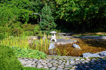 Japanese Garden. pond and lantern. botanical park in early autumn. Sunny Autumn Day