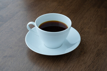 cup of black coffee on a table with a wood texture