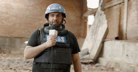 POV War journalist correspondent wearing bulletproof vest and helmet reporting live near destroyed building