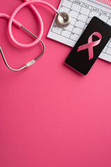 Breast cancer awareness concept. Top view vertical photo of pink ribbon over smartphone calendar...