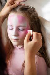Master making aqua makeup on girl face. animator artist draws painting face art on birthday party....