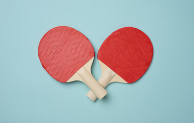 Pair of wooden tennis rackets for ping pong on a blue background