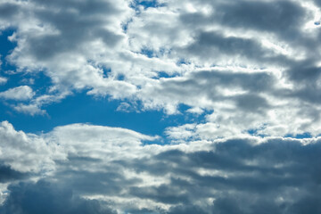 Blue sky with thunderclouds. The sun breaks through the clouds. Black clouds.