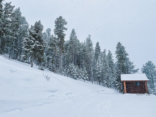 snowy rocky mountain landscape and cabin