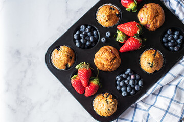 Blueberry and strawberry muffins with berries. Top view and copy space. - 535918906
