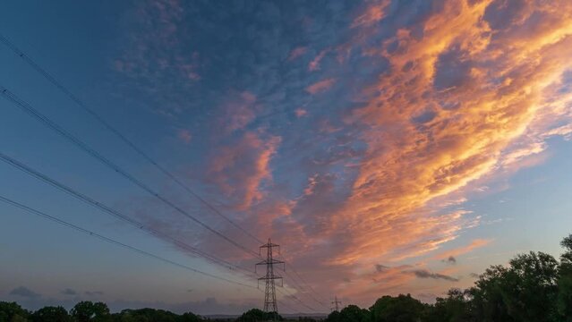 silhouette of power lines against a beautiful sunset with clouds