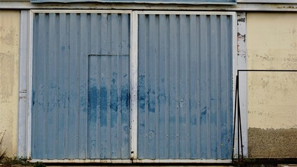 Fototapeta na wymiar worn metal warehouse door of industrial building