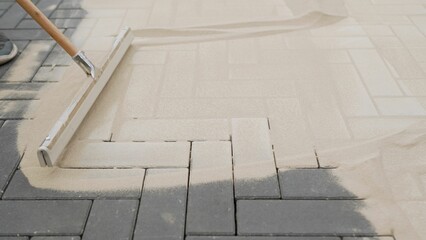 Laying paving slabs on the paths of the reconstructed park and filling the joints with sand. Paving...
