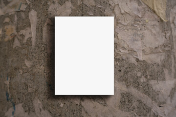 Empty vertically fixed on shabby concrete wall white poster with mockup space