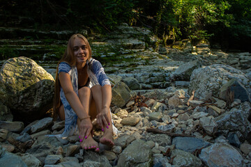 beautiful blonde in a swimsuit walks in the mountains