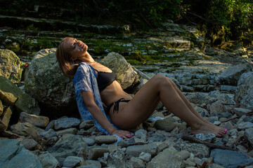 beautiful blonde in a swimsuit walks in the mountains