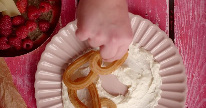 Flat lay food recipe: chef puts churos to the plate with cream