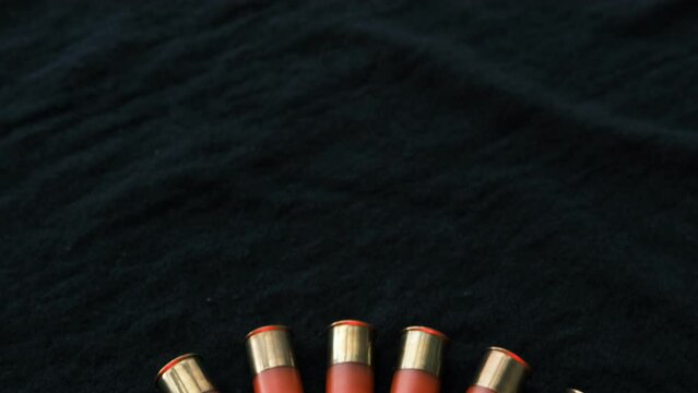 Red Shotgun shells on a black surface. Ammunition for 12 gauge smoothbore weapons. Hunting ammunition. Dark background