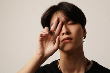 Fototapeta premium Close-up of young asian man posing on the white wall. Mental health issues.
