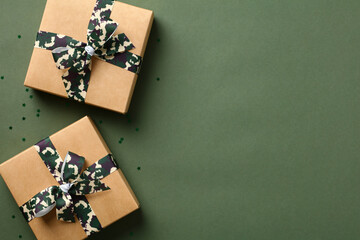 Gift boxes with camouflage military ribbon bow on green table. USA Veterans Day, Defender of the...